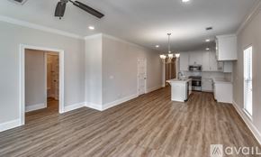 Brandon house for rent - A spacious room with wooden flooring and a kitchen area in the background.