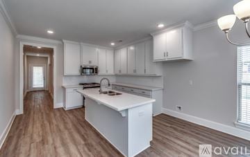 Brandon house for rent - A kitchen with white cabinets and a wooden floor.