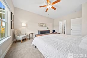 Knoxville house for rent - A bedroom with a large bed and a ceiling fan.