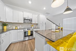 Knoxville house for rent - A modern kitchen with white cabinets and a yellow bench.