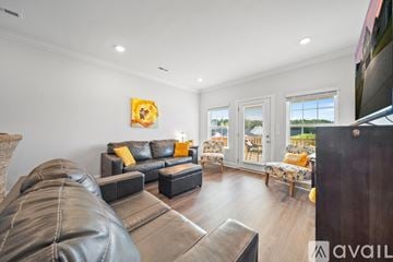 Knoxville house for rent - A living room with a leather couch and a painting on the wall.