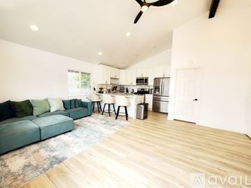 San Diego apartment for rent - A living room with a green couch and a kitchen in the background.