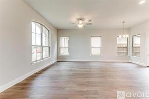 Mansfield house for rent - A spacious room with wooden floors and large windows.
