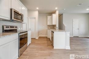 Mansfield house for rent - A kitchen with white cabinets and a wooden floor.