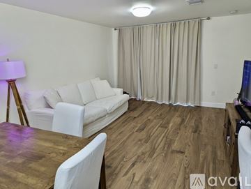 Doral apartment for rent - A living room with a white couch and wooden floors.