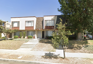 Chatsworth apartment for rent - A tree is in front of a building with a brown door.