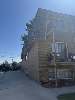 Moorhead apartment for rent - A house with a balcony and a car parked in the driveway.