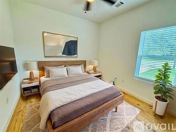 Brenham house for rent - A bedroom with a large bed and a flat screen TV mounted on the wall.