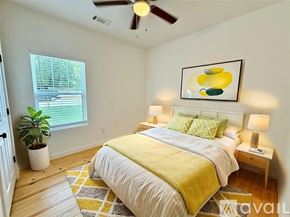 Brenham house for rent - A bedroom with a bed, a ceiling fan, and a painting on the wall.