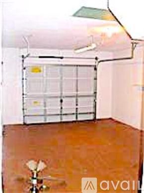 Cape Coral house for rent - A room with a brown floor and a white wall with a window covered by a white curtain.