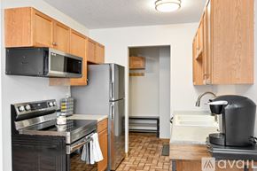 Hopkins condo for rent - A kitchen with wooden cabinets and a black stove top oven.