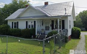 Goldsboro house for rent - A white house with a grey roof and a fence in front.