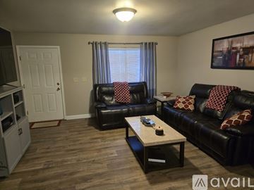 St. Peters house for rent - A living room with black leather couches and a wooden coffee table.