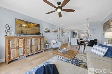 Carlsbad apartment for rent - A living room with a large painting on the wall and a wooden cabinet.