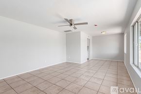 Mesa house for rent - A spacious room with a ceiling fan and tiled flooring.