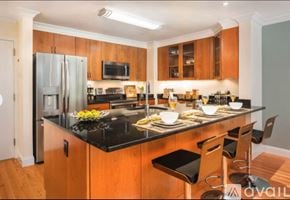 Brookline apartment for rent - A kitchen with wooden cabinets and black countertops.