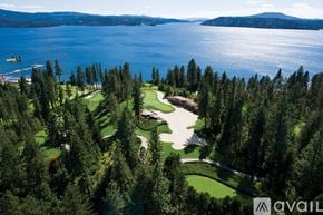 Coeur D'alene house for rent - A golf course surrounded by trees and a body of water.
