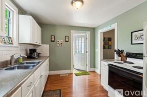 Coeur D'alene house for rent - A kitchen with white cabinets and a black stove top oven.