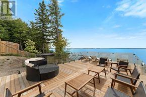 Brock house for rent - A wooden deck with chairs and a hot tub overlooking a body of water.