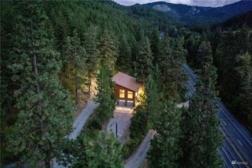 Wenatchee house for rent - A house is surrounded by trees and is lit up at night.