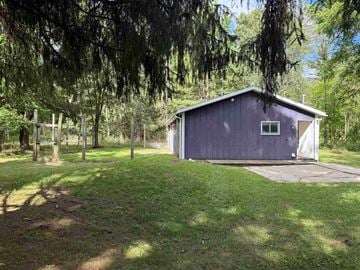 Fenwick house for rent - A small blue building sits in a grassy field.