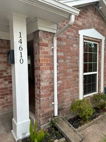 Houston house for rent - A white house with a brick wall and a window.