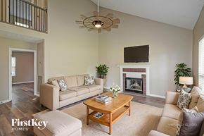 Hendersonville house for rent - A living room with a couch, a coffee table, a fireplace, and a television.