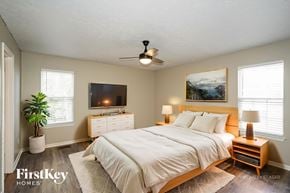 Hendersonville house for rent - A bedroom with a bed, nightstands, and a ceiling fan.