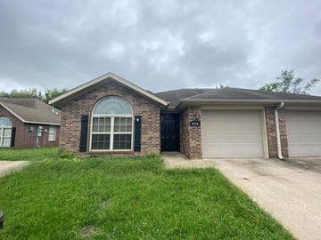 Rogers house for rent - A house with a brick facade and a large arched window.