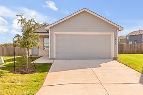 San Antonio house for rent - A house with a white garage door and a tree in front.