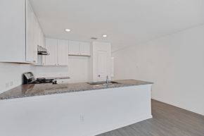 San Antonio house for rent - A kitchen with white cabinets and a granite countertop.