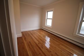 Lowell apartment for rent - A room with wooden floors and a window.
