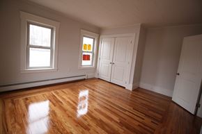 Lowell apartment for rent - A room with wooden floors and white walls.