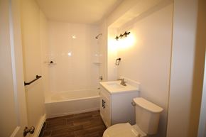 Lowell apartment for rent - A small white bathroom with a toilet, sink and bathtub.