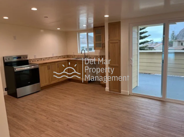 Morro Bay house for rent - A kitchen area with a stove and a countertop with a logo for Det Mar Property Management.