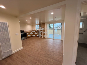 Morro Bay house for rent - A spacious room with wooden flooring and a large window.
