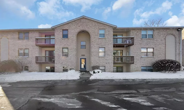 Blue Ash apartment for rent - A large brick building with a parking lot in front.
