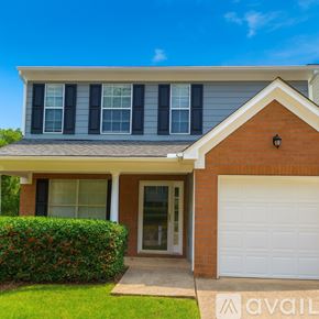 Atlanta house for rent - A house with a white garage door and a brick chimney.
