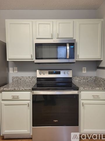 Atlanta house for rent - A kitchen with white cabinets and a black stove top oven.