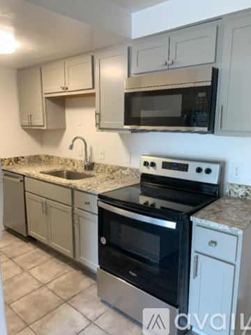 Cincinnati apartment for rent - A kitchen with a stove, oven, microwave, and cabinets.