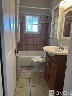 Oswego apartment for rent - A bathroom with a toilet, sink, and shower.