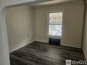 Scranton house for rent - A room with wooden flooring and a window showing a fence and trees outside.