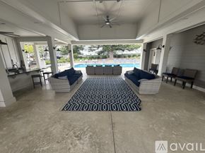 Hampstead house for rent - A patio with a pool in the background and a rug on the floor.