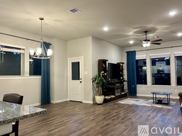 Willis house for rent - A spacious living room with a marble table and a ceiling fan.