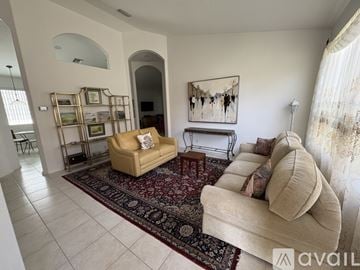 Delray Beach house for rent - A living room with a beige couch and a rug.