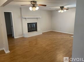 Mandeville house for rent - A room with a fireplace and a ceiling fan.