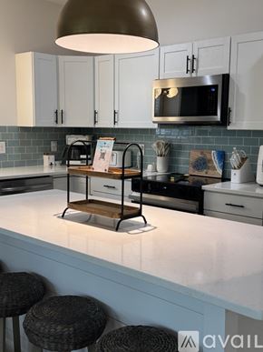 Oak Island house for rent - A kitchen with a white counter top and a microwave above it.