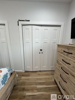 Oak Island house for rent - A bedroom with a bed, a dresser, and a wardrobe labeled "Owners Closet".