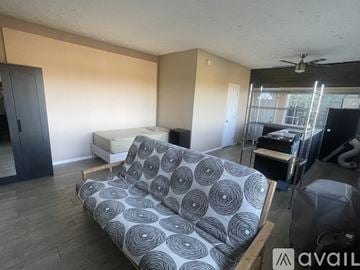 Los Angeles house for rent - A living room with a grey couch and a fan on the ceiling.
