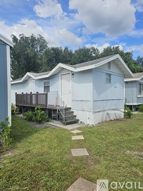 Gibsonton apartment for rent - A white mobile home with a deck and a small garden.